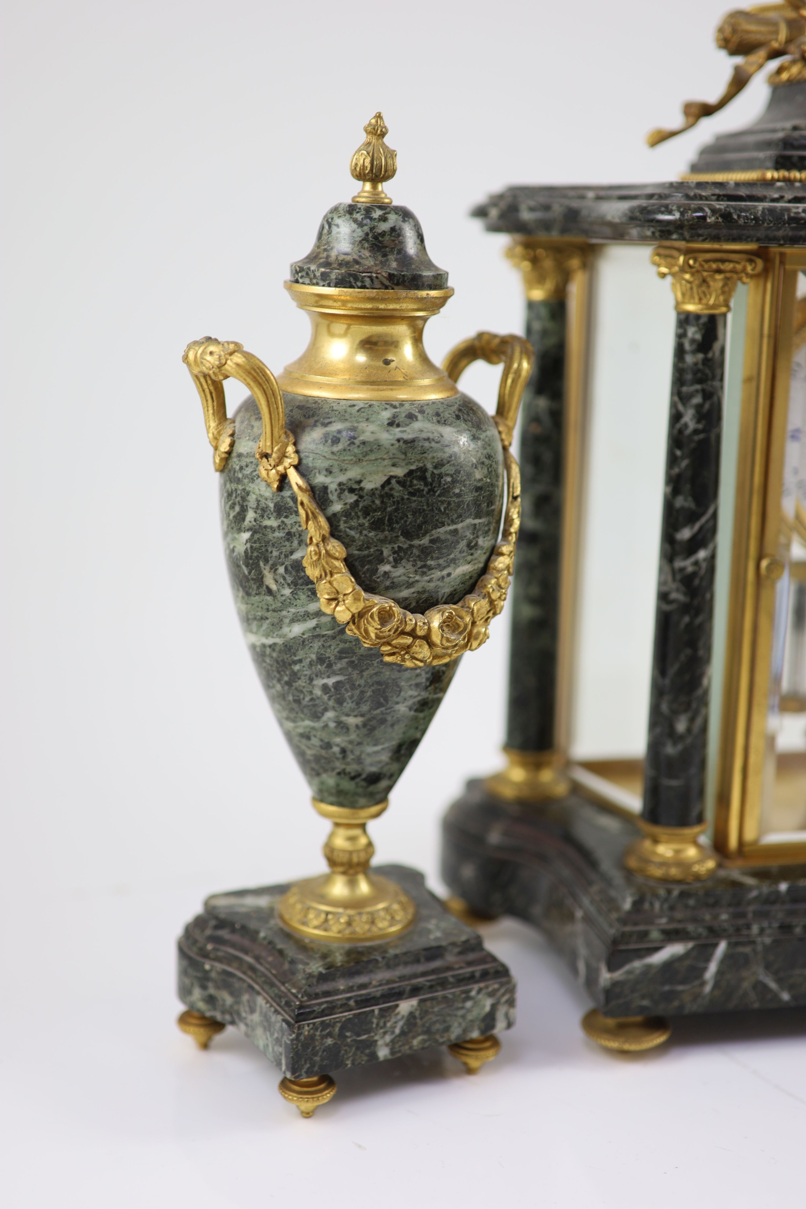 A 19th century French ormolu mounted black variegated three piece clock garniture H 38cm. W 27cm. D 14cm. The urns 31cm high.